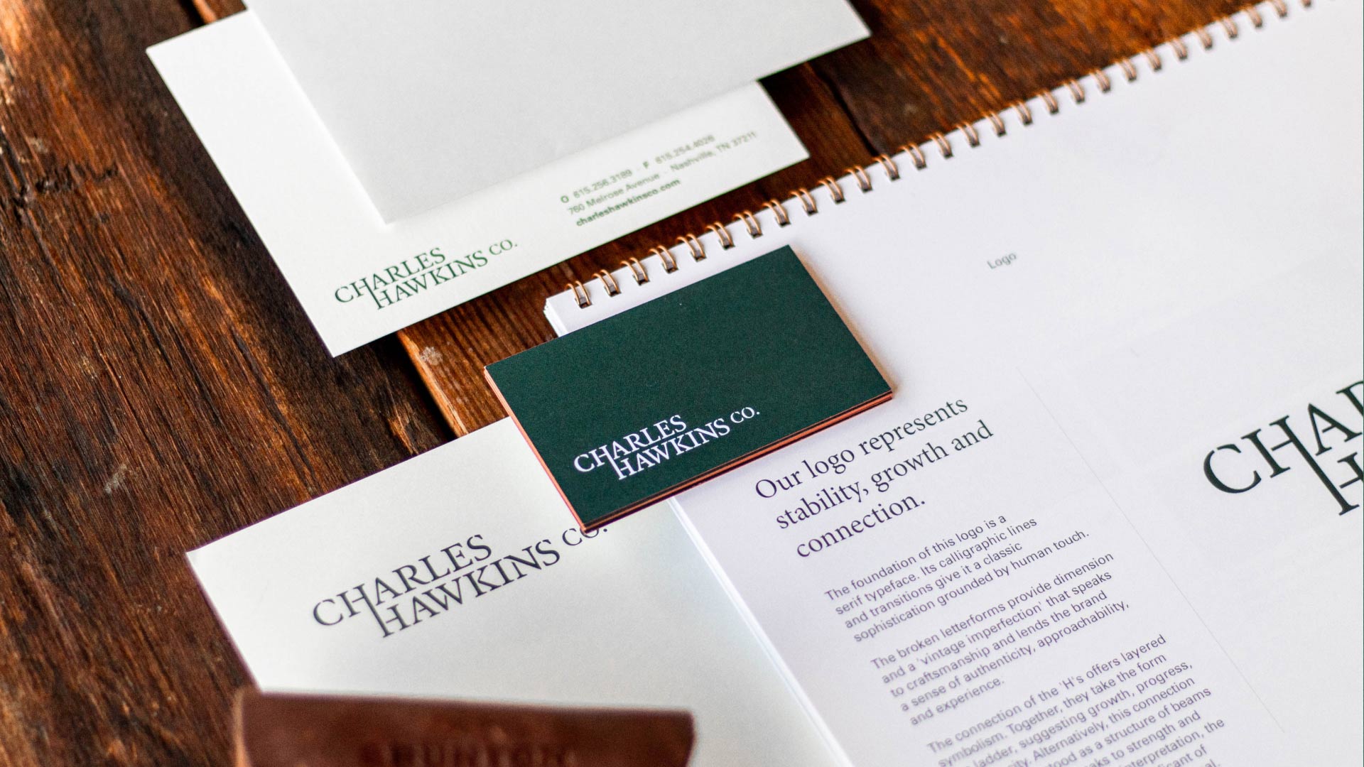 Flat lay of print collateral featuring the Charles Hawkins Co. branding
