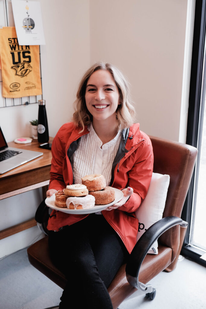 A photo of Emily Little holding a plate of donuts on one of her first days at Circa. 